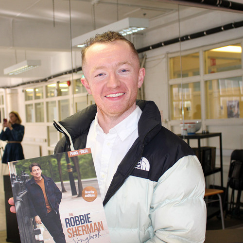 Millennium Performing Arts Alumni proudly showing his new copy of The Robbie Sherman Songbook. (2022)